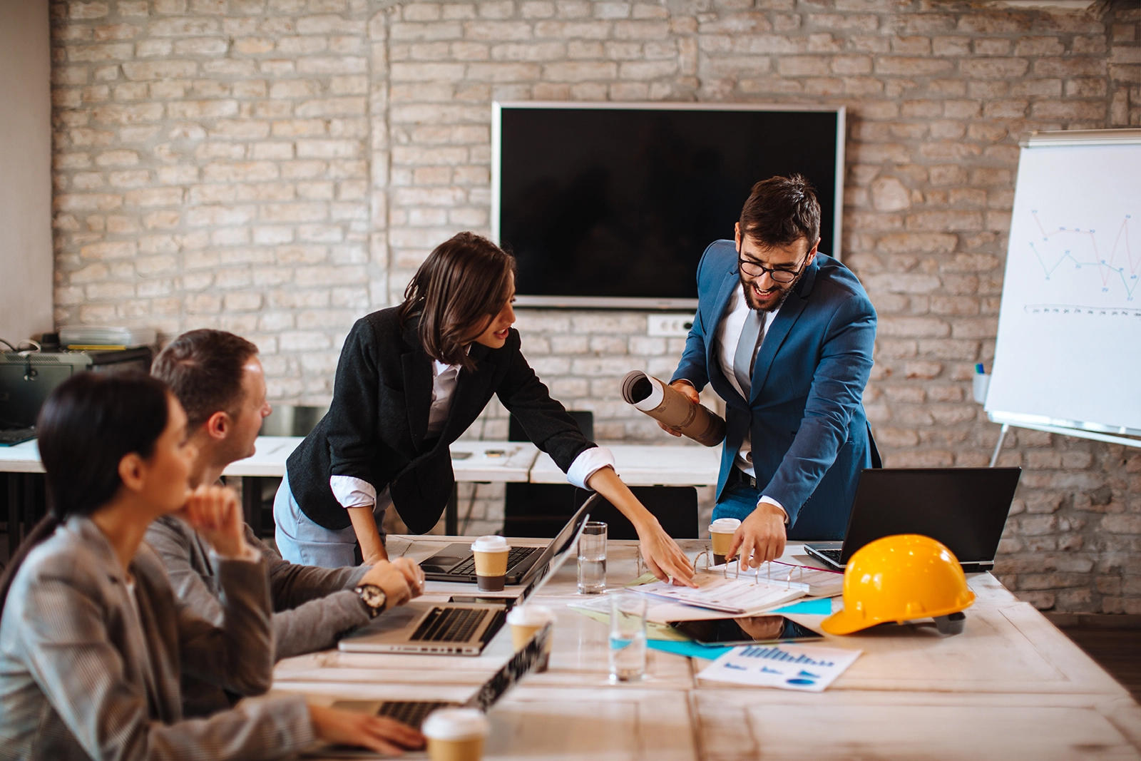 Business Team diskutiert Baupläne und Strategien als Symbol für professionelles Recruiting